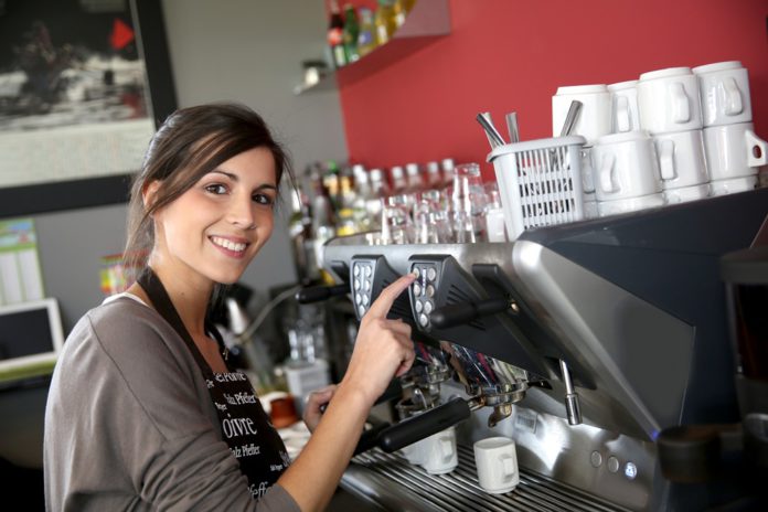 Waitress serving coffee from machine