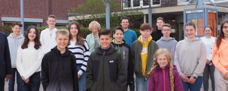 Jugendliche schauen Stadtmitarbeitenden über die Schulter