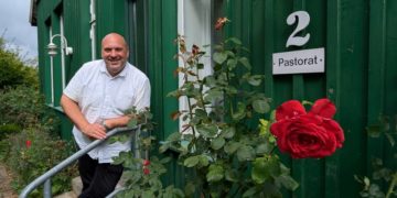 Pastor mit Harley und HSV-Schal 