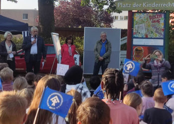 Grundschulkinder verwandeln Platz der Kinderrechte in blaues Fahnenmeer