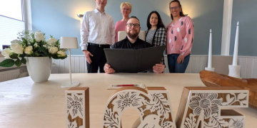 Standesamt-Leiter Philipp Plaukowitsch (Mitte) mit seinem Team im Trauzimmer des Geesthachter Rathauses. Foto: Stadt Geesthacht – Wiebke Jürgensen, hfr