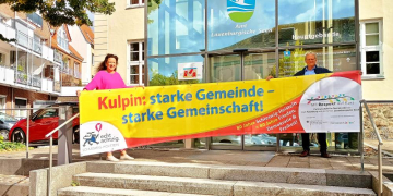 Gesine Biller vom Bündnis für Demokratie und Menschenrechte in Ratzeburg und Umland und Amtsvorsteher Heinz Dohrendorff präsentieren das Straßenbanner der Gemeinde Kulpin. Foto: Thomas Biller